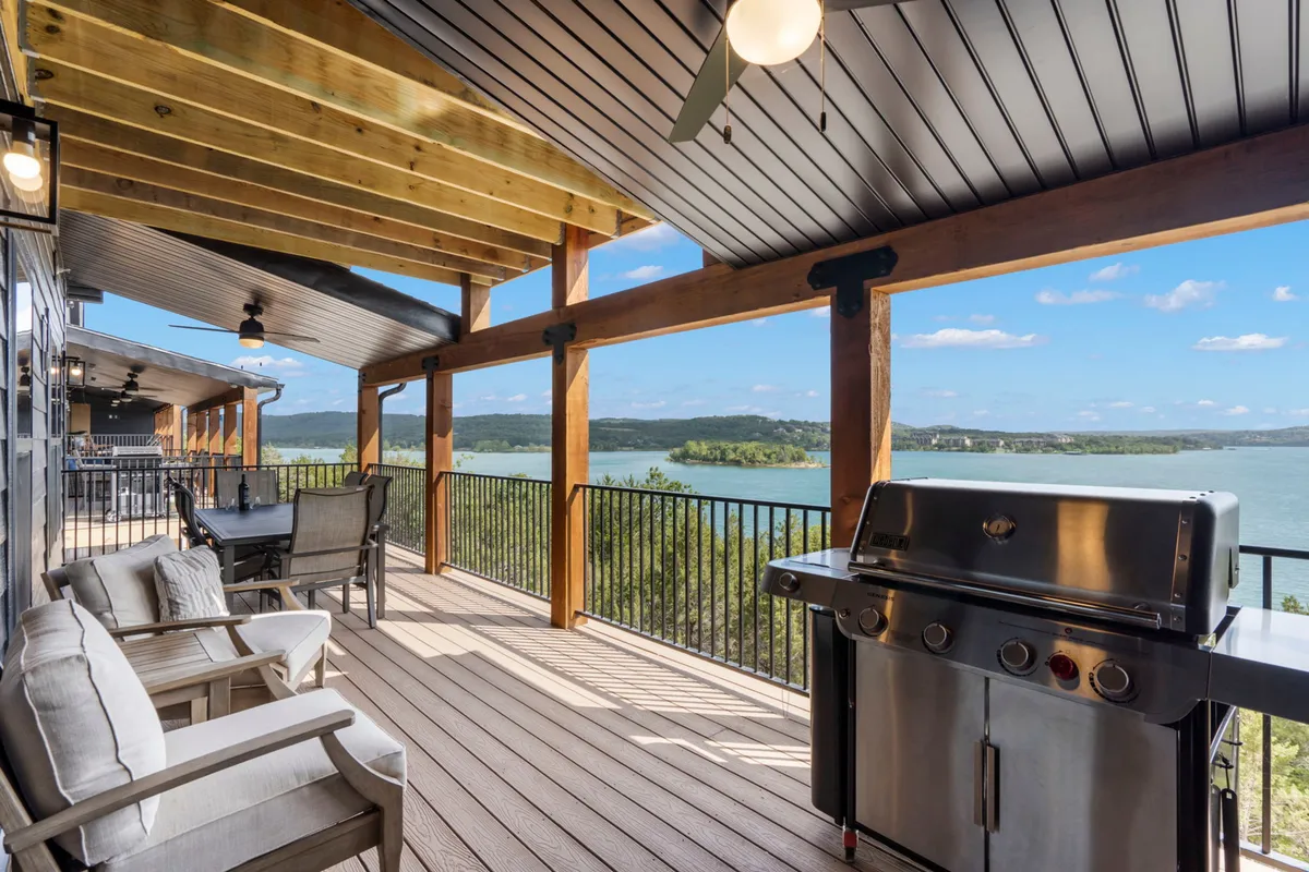A relaxed outdoor seating area with a grill overlooks the sparkling lake. Guests can enjoy barbecues, outdoor dining, or simply unwind while taking in sunset views over the water.