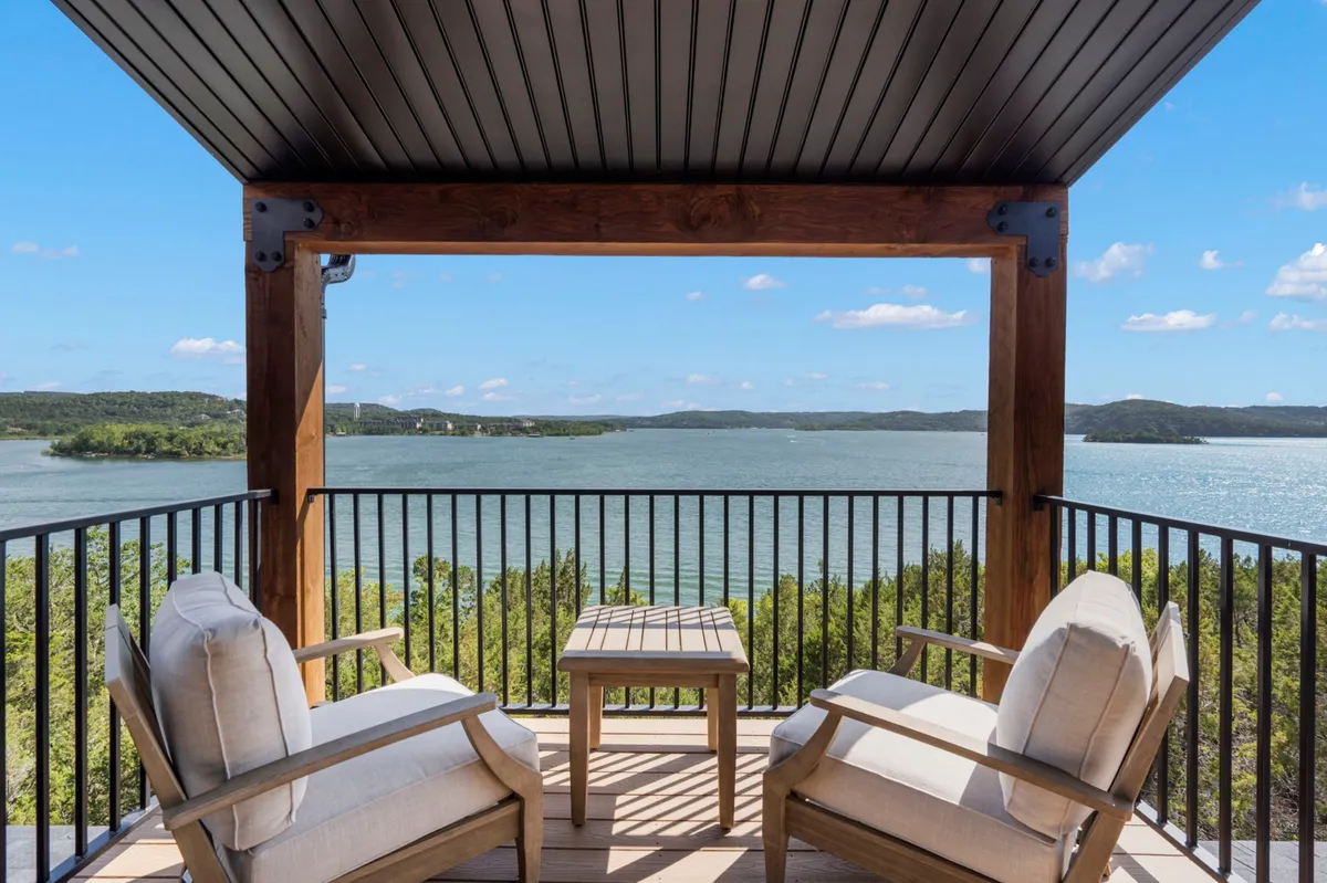 The image features a serene lake view framed by a wooden pergola with comfortable outdoor seating, inviting guests to relax and soak in the natural beauty. The tranquil setting is perfect for enjoying a morning coffee, watching the sunset, or stargazing at night, with sweeping panoramic vistas and lush surroundings.